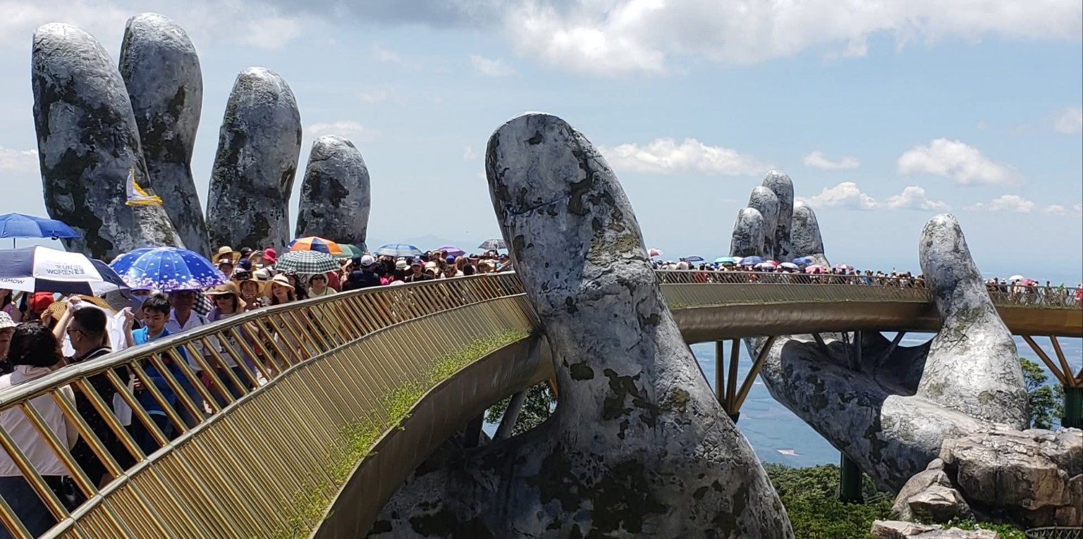 The Golden Bridge at Sun World Ba Na Hills held by two giant stone hands above the clouds