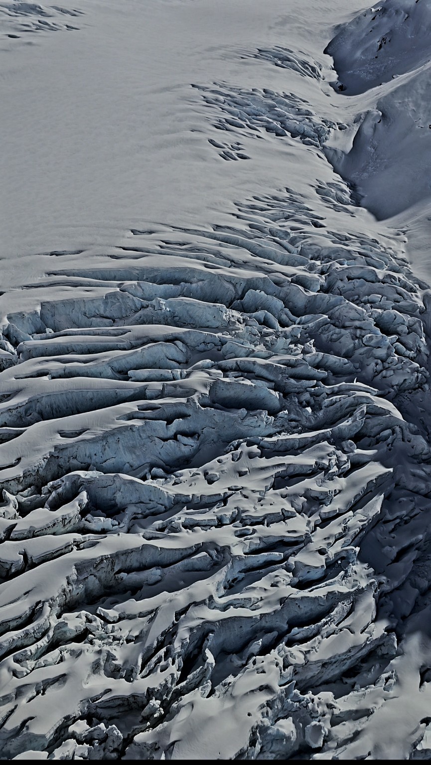Snowfield and sculpted alpine ice beneath a deep blue sky