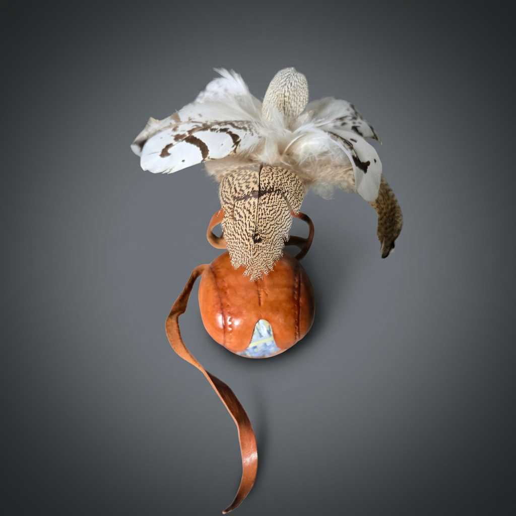 Qatari leather falcon hood (burqu) with hand-stitched orange leather, feather plume, and painted panel