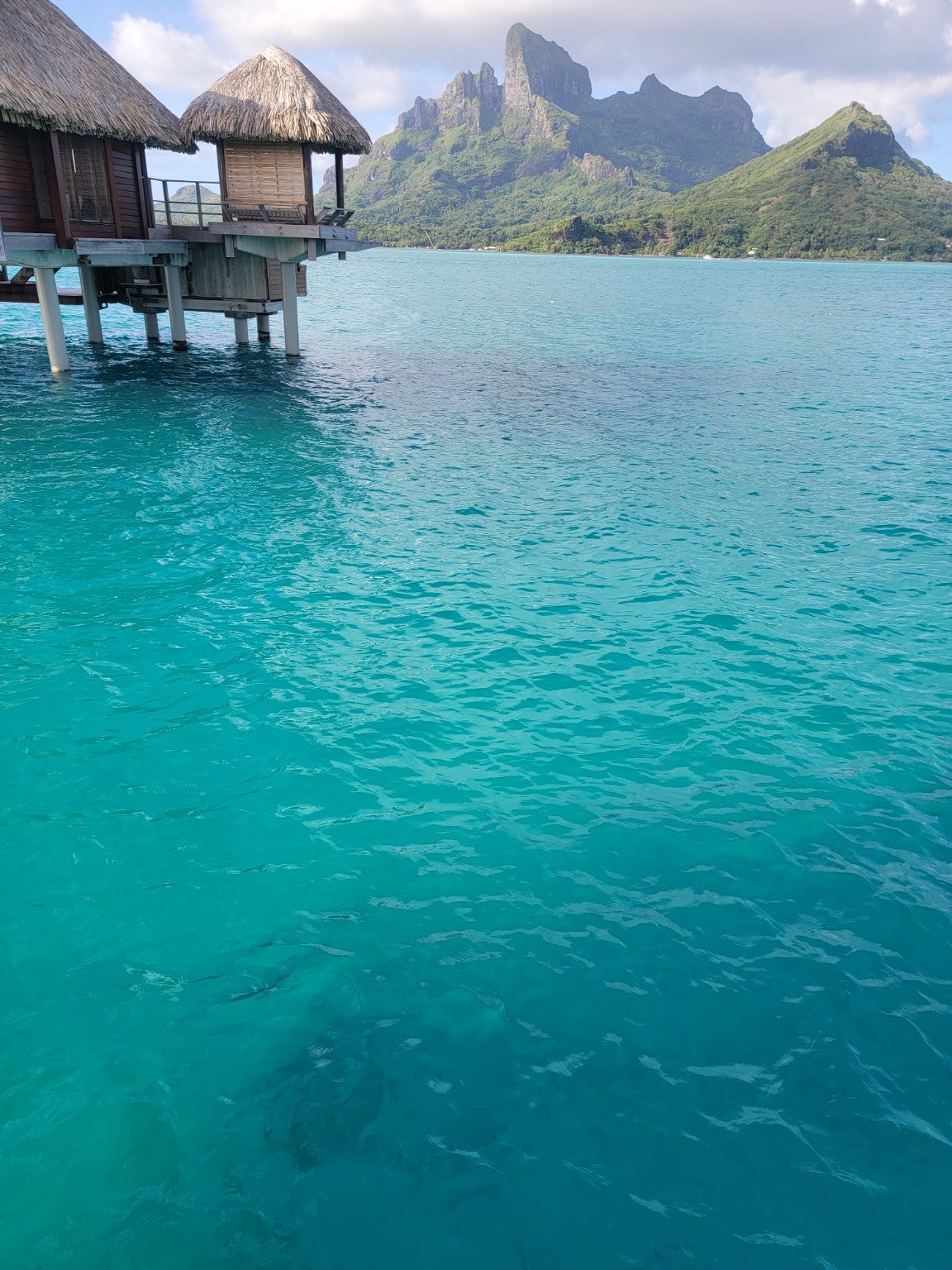 Turquoise Bora Bora lagoon with the jagged silhouette of Mount Otemanu rising in the distance