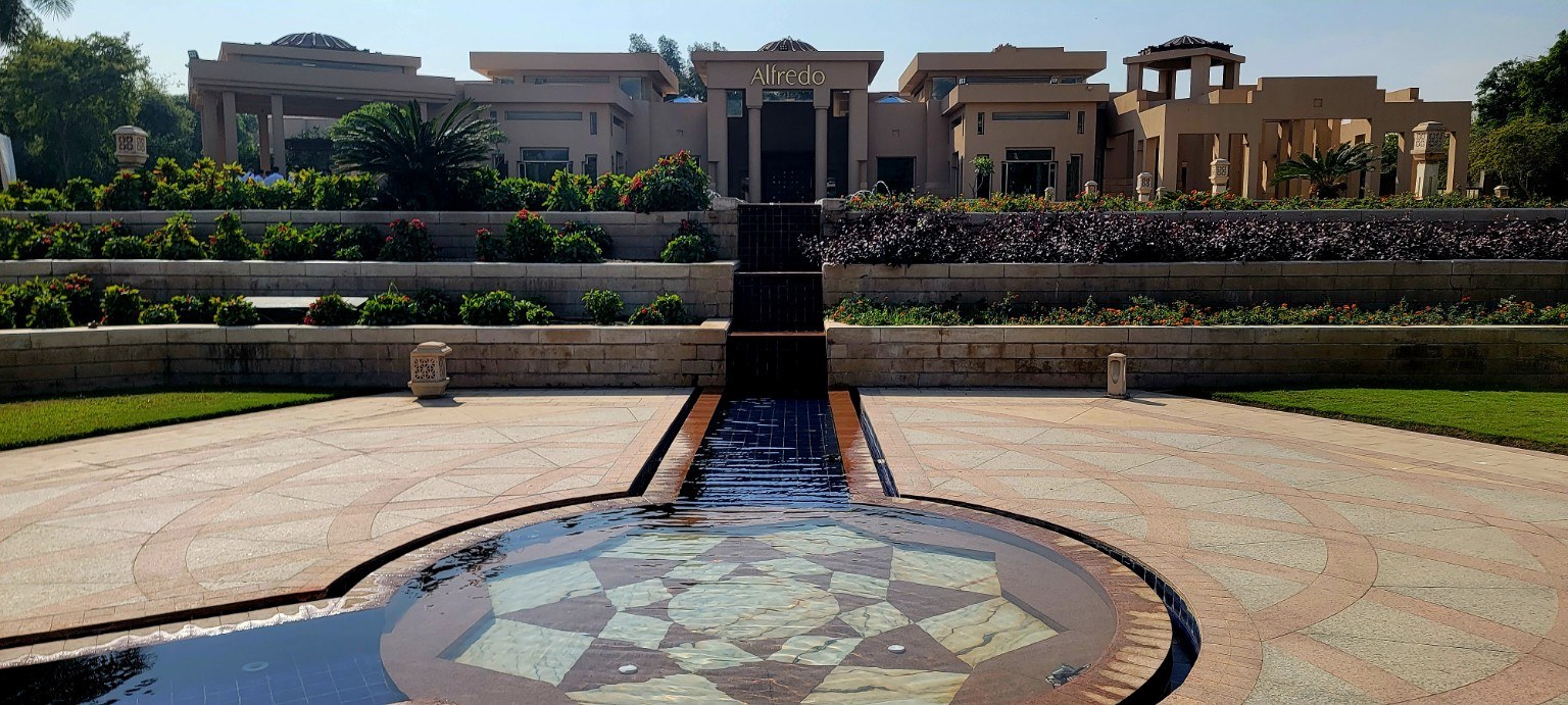 Manicured gardens and palms in the courtyard of Marriott Mena House with the Great Pyramid in the background