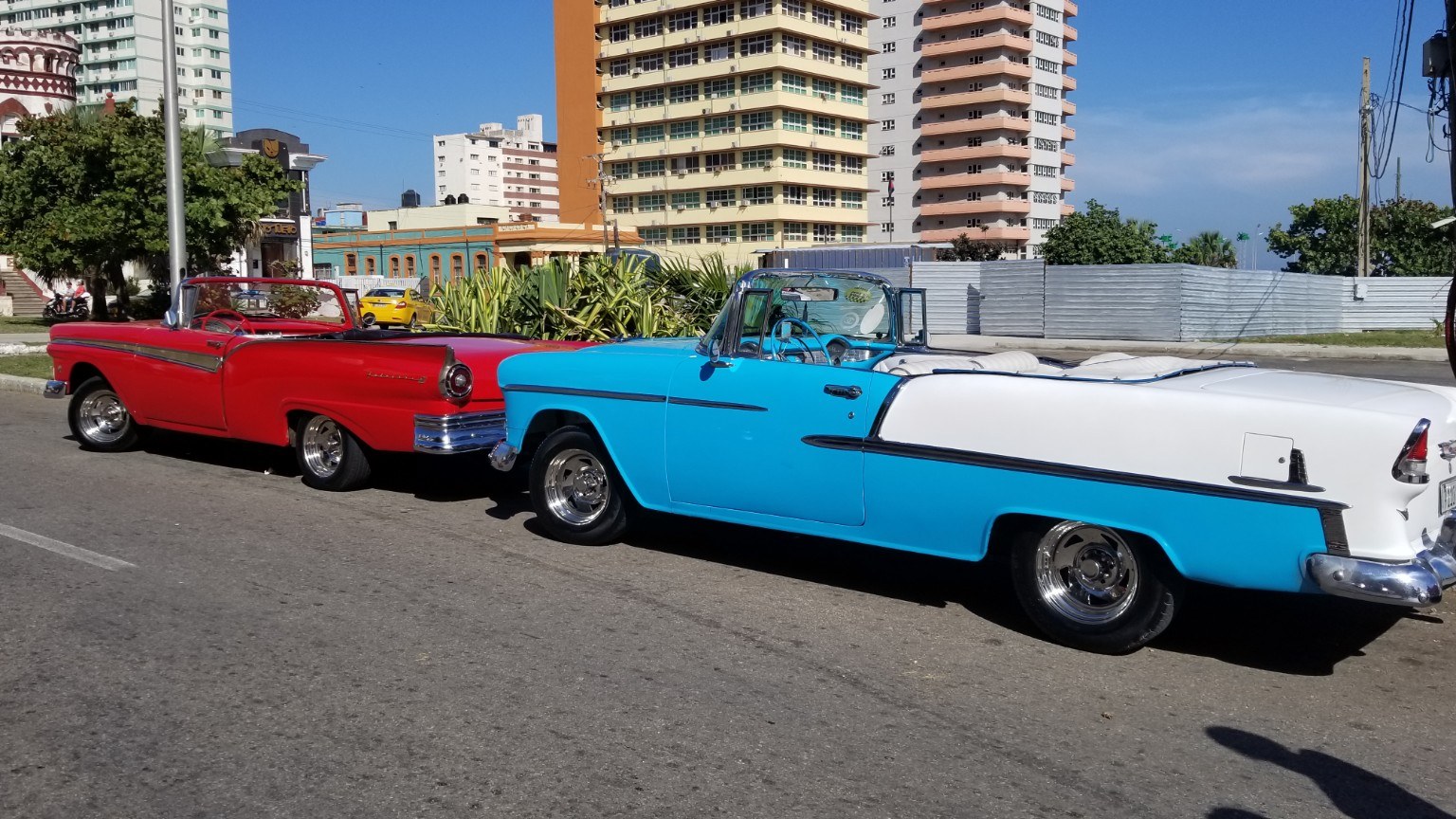 Red and turquoise 1950s American convertibles parked along Havana's Malecón
