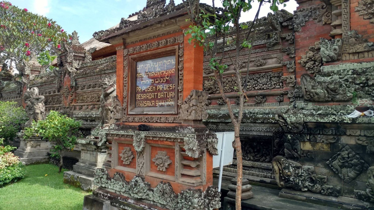 Temple walls with carved stonework, inscriptions, and red brick details