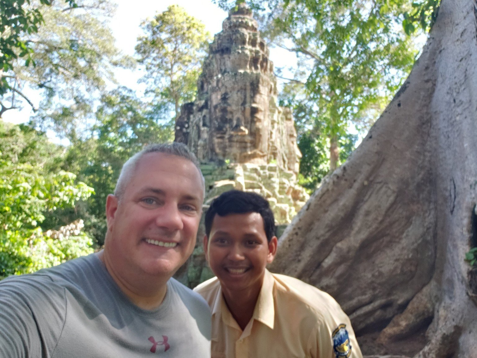 Standing with a local guide at Ta Prohm, where tree roots grip the temple stones