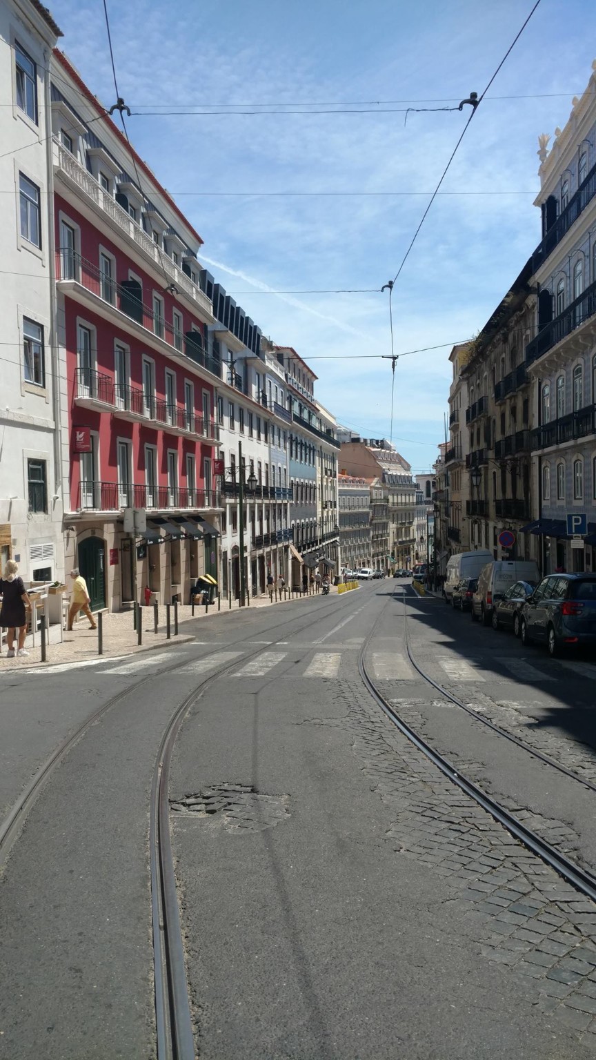 Lisbon street with tram tracks descending toward the river