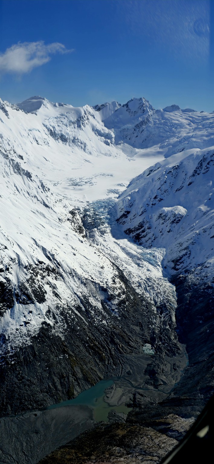 Aerial view of crevassed glacier ice and a proglacial basin