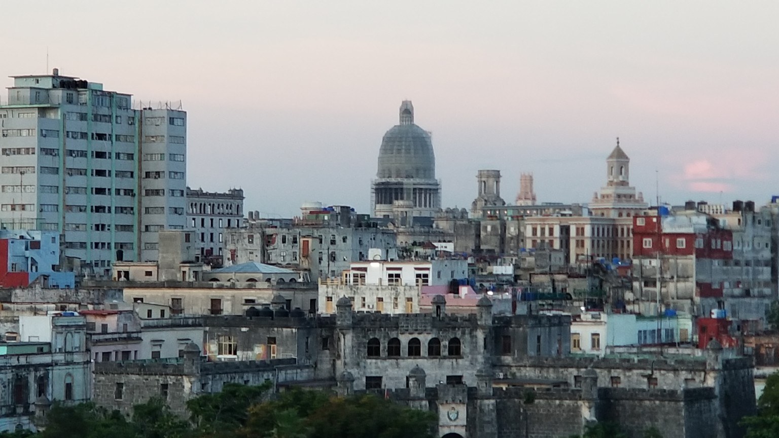 Havana skyline at dusk with the Capitolio dome rising above colonial rooftops