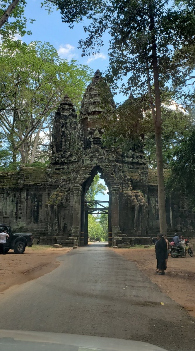 A stone gate into the Angkor complex flanked by jungle trees
