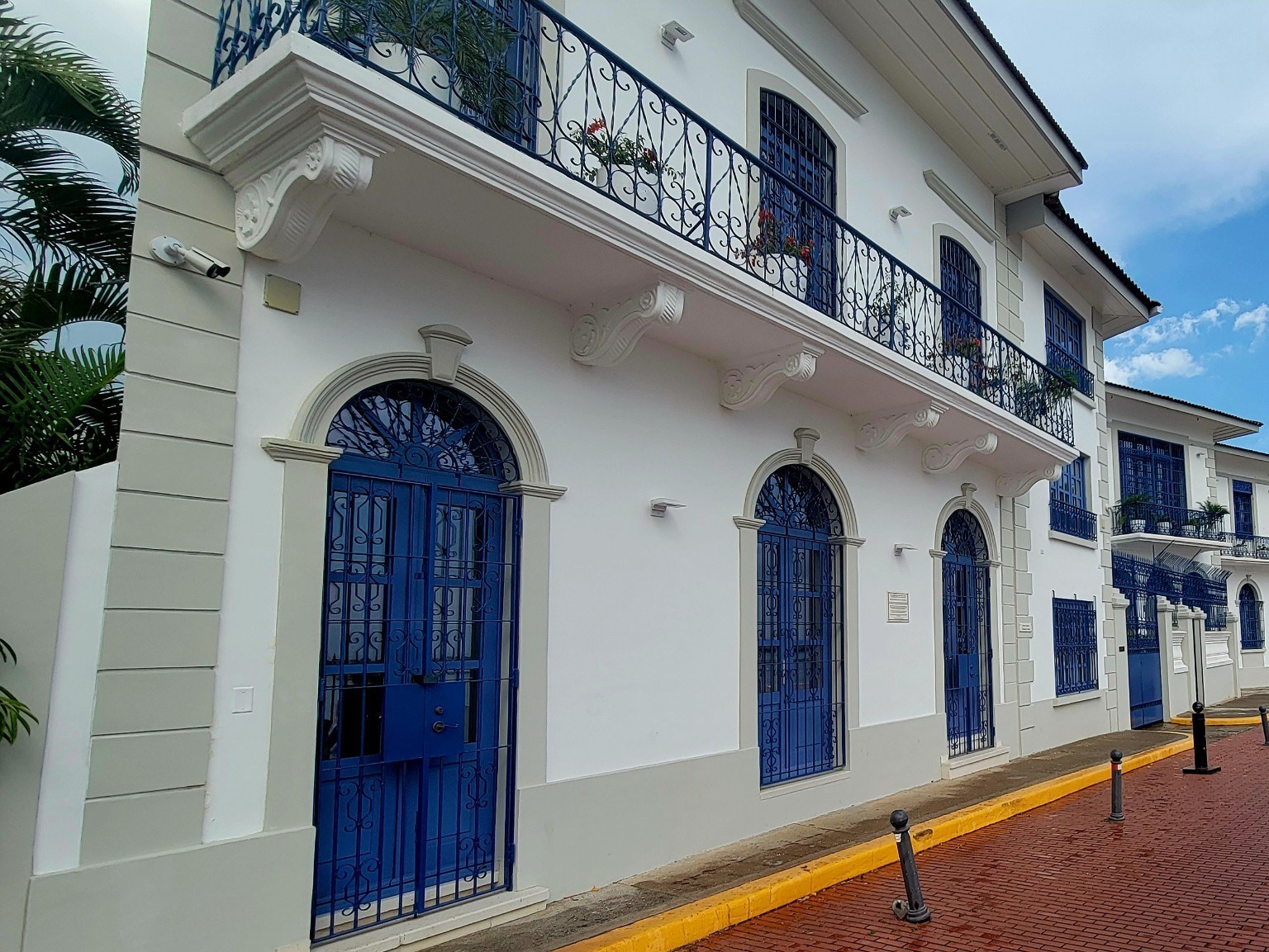 Whitewashed Casco Viejo building with deep blue doors, windows, and ironwork