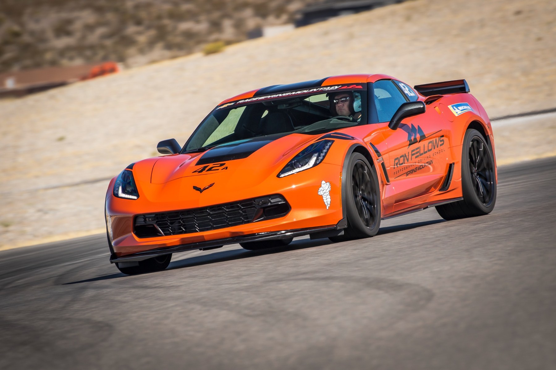 Corvette on track with desert hills behind it