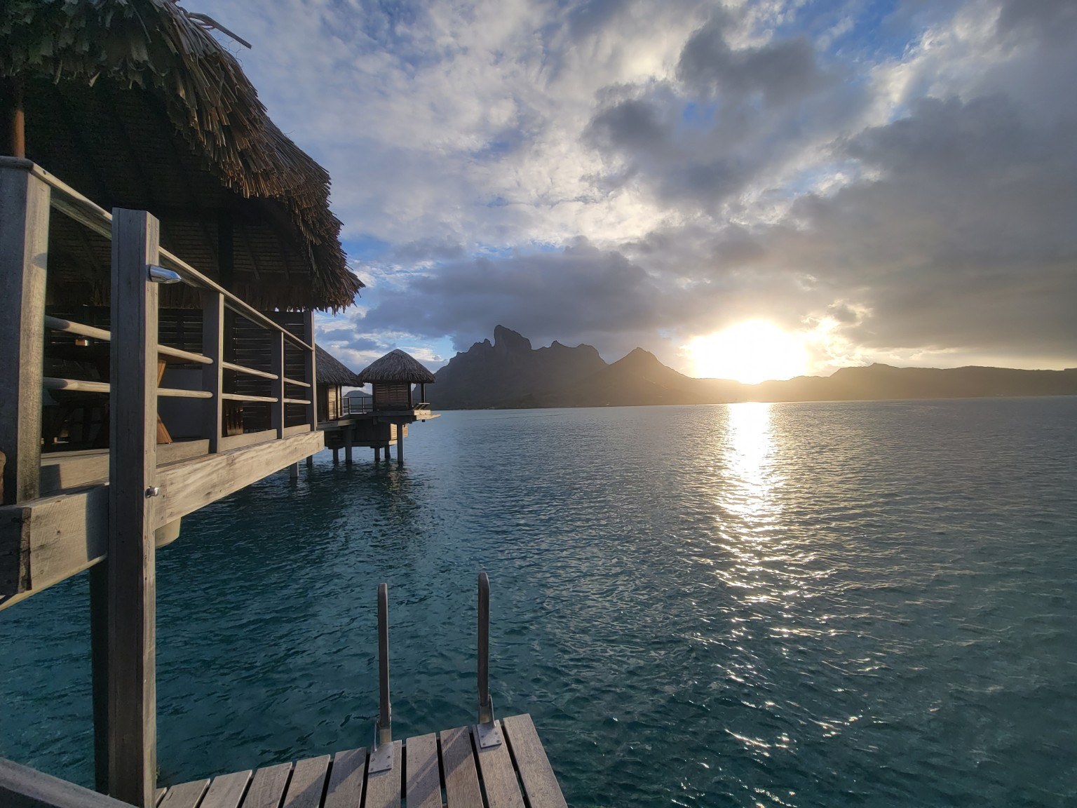 Sunrise from an overwater bungalow in Bora Bora with Mount Otemanu in the distance