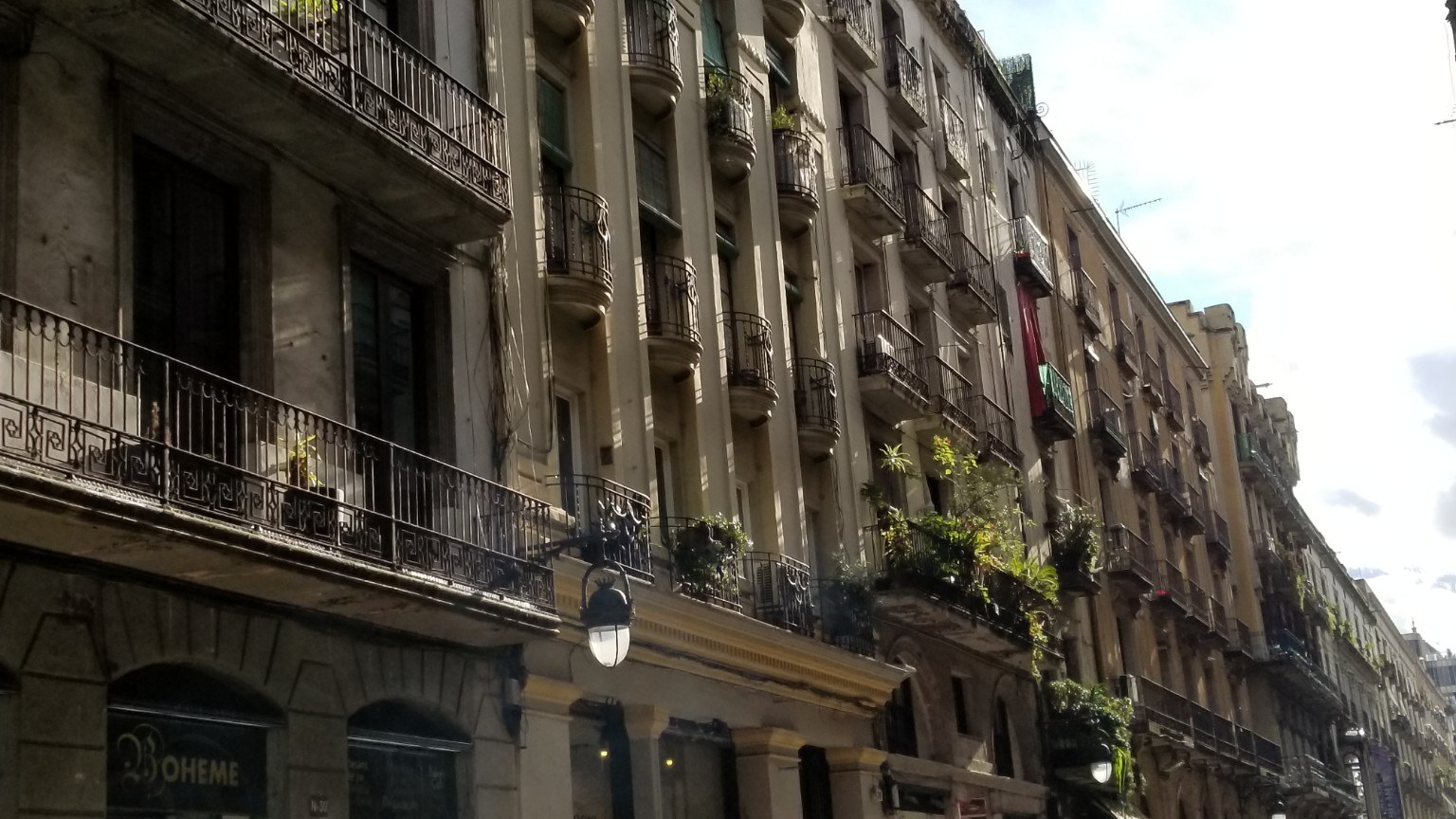 Barcelona balconies and old stone façades on a narrow street