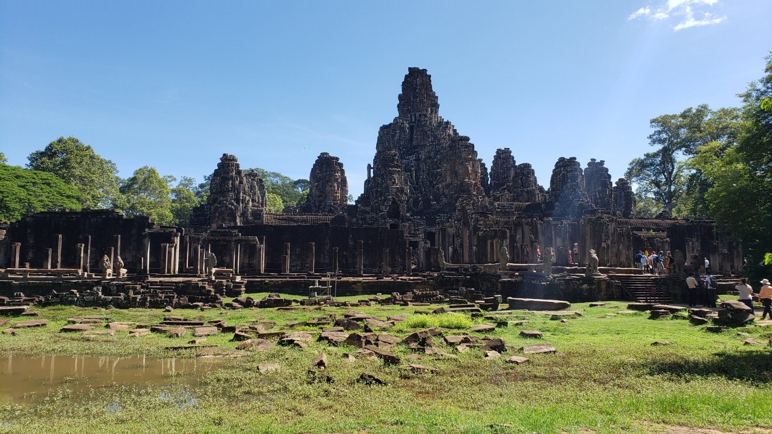 A wide view of Bayon Temple inside Angkor Thom, its stacked stone towers rising in tiers
