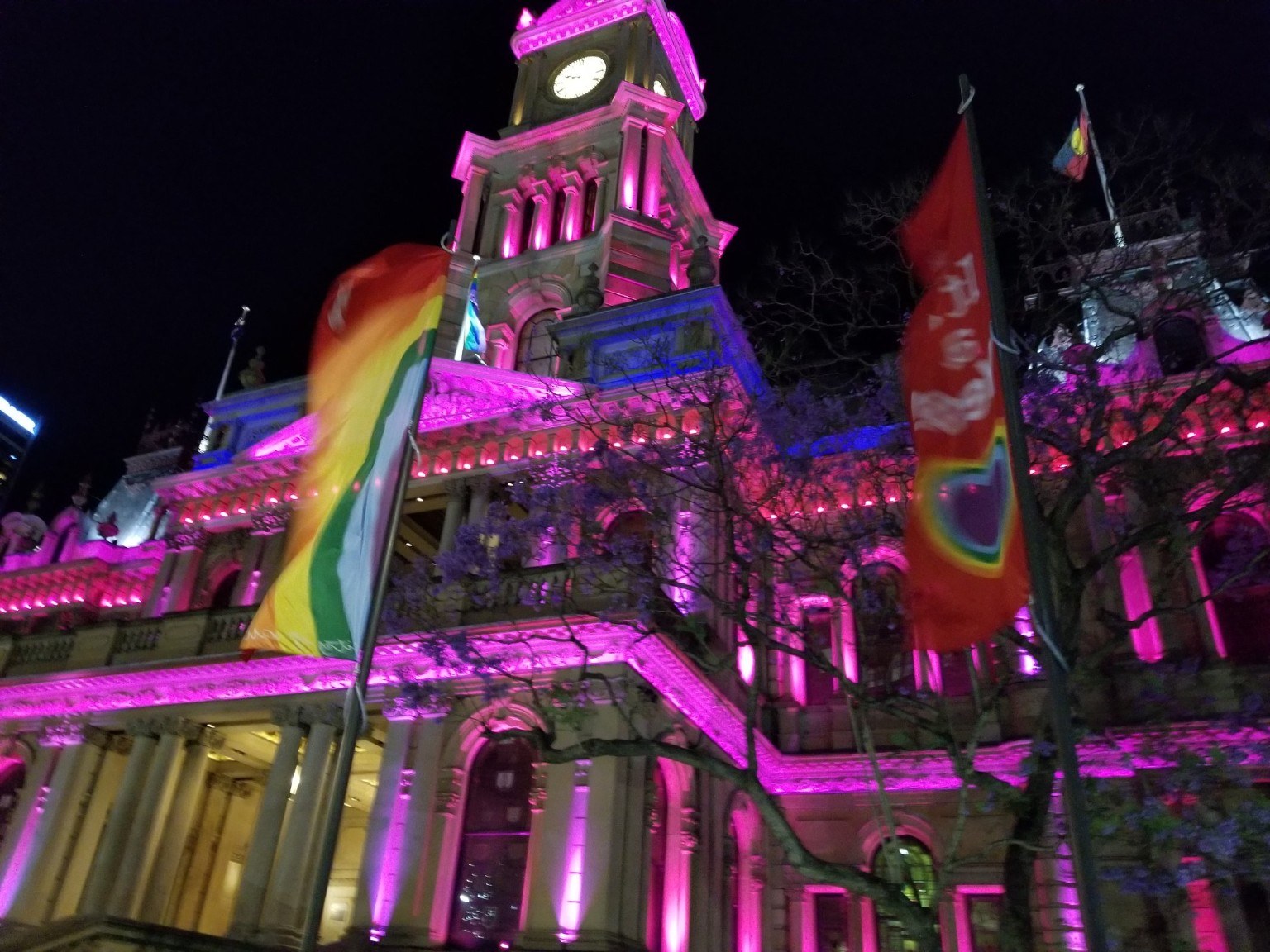 Customs House lit up in pink and rainbow colors at night