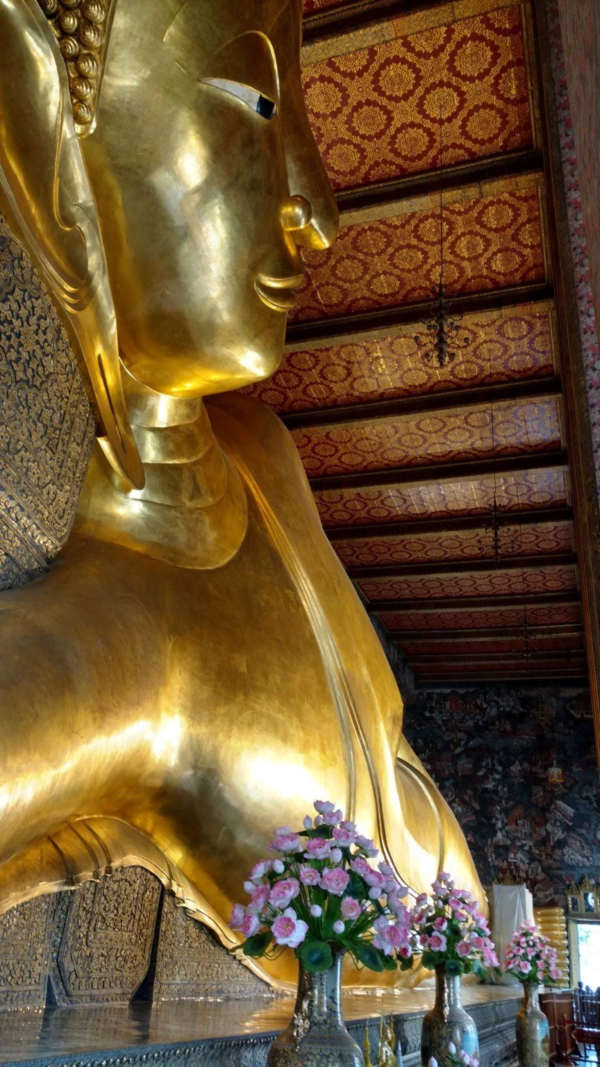 The Reclining Buddha at Wat Pho, a massive gold statue stretching the length of the hall