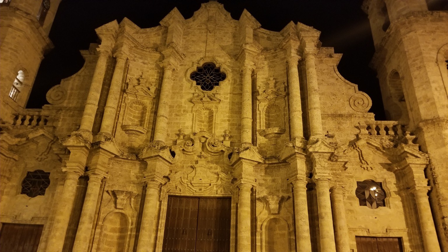 Stone facade of the Catedral de San Cristóbal in Old Havana lit warm against the night sky