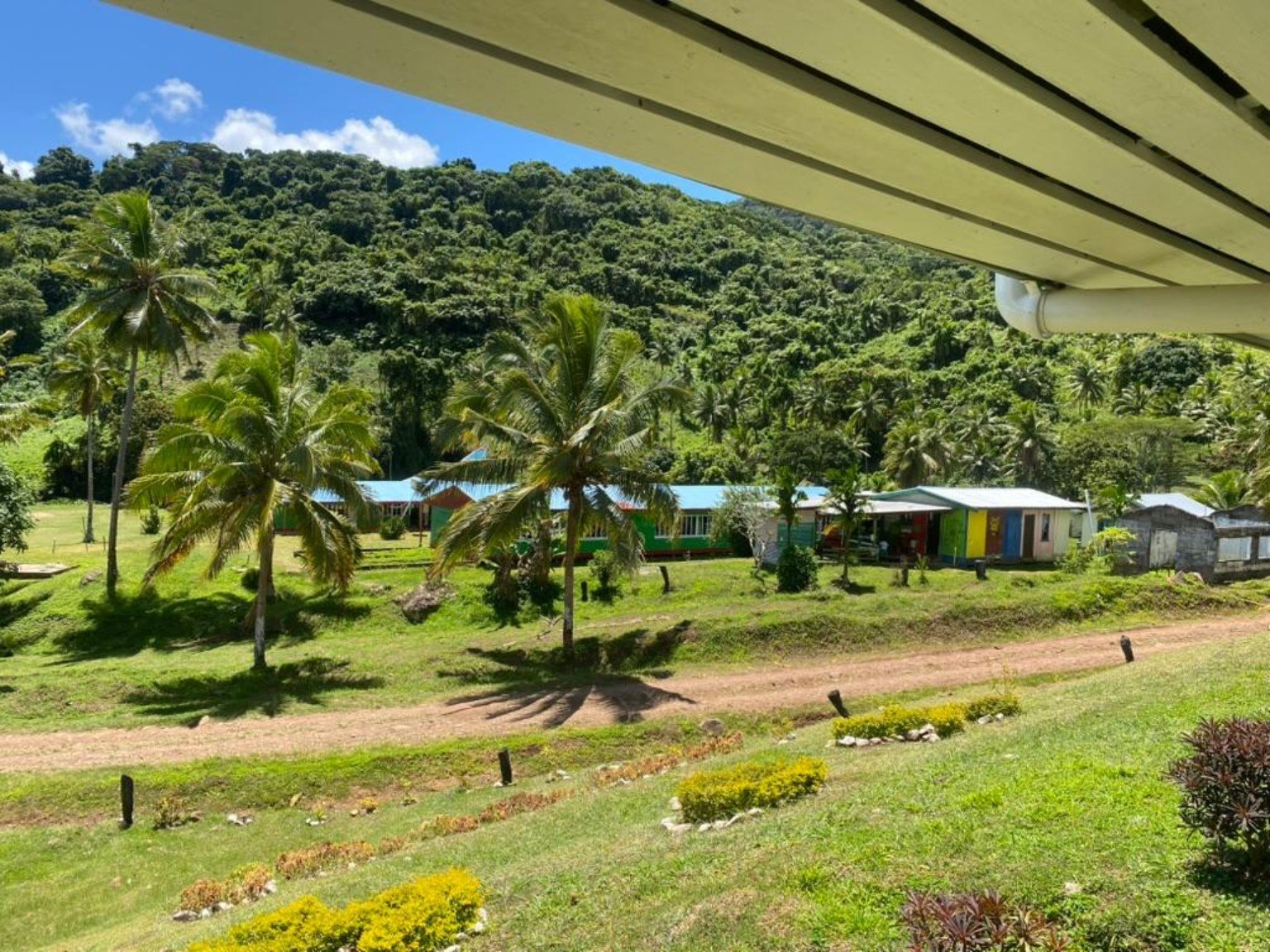 View across the school grounds toward lush hillside