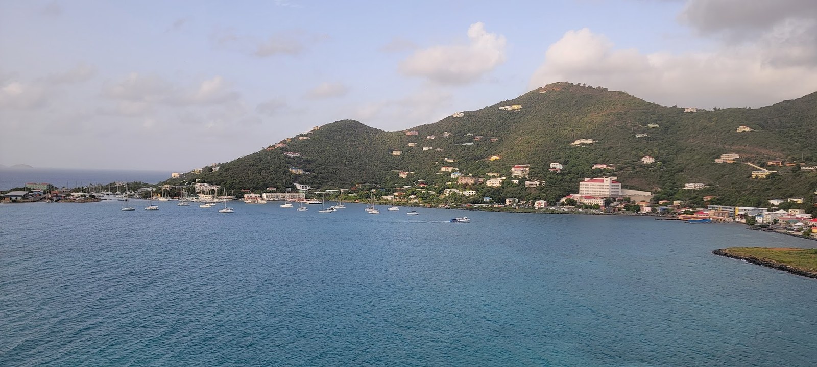 Tortola wakes up in soft morning light, with Road Town and the harbor layered against green volcanic hills.