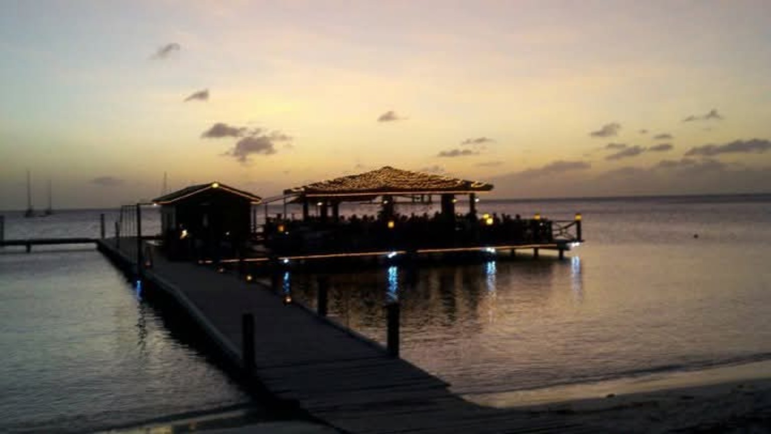 A dockside restaurant glowing at dusk in Aruba
