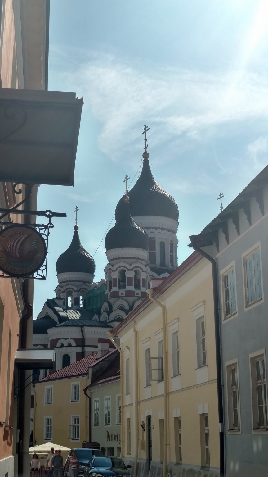 Street-level view of Alexander Nevsky Cathedral framed by pastel buildings in Tallinn Old Town