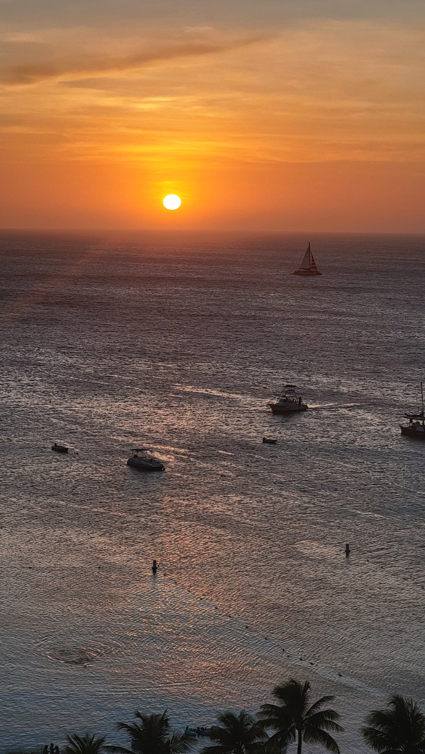 A sunset sail crossing the horizon in Aruba