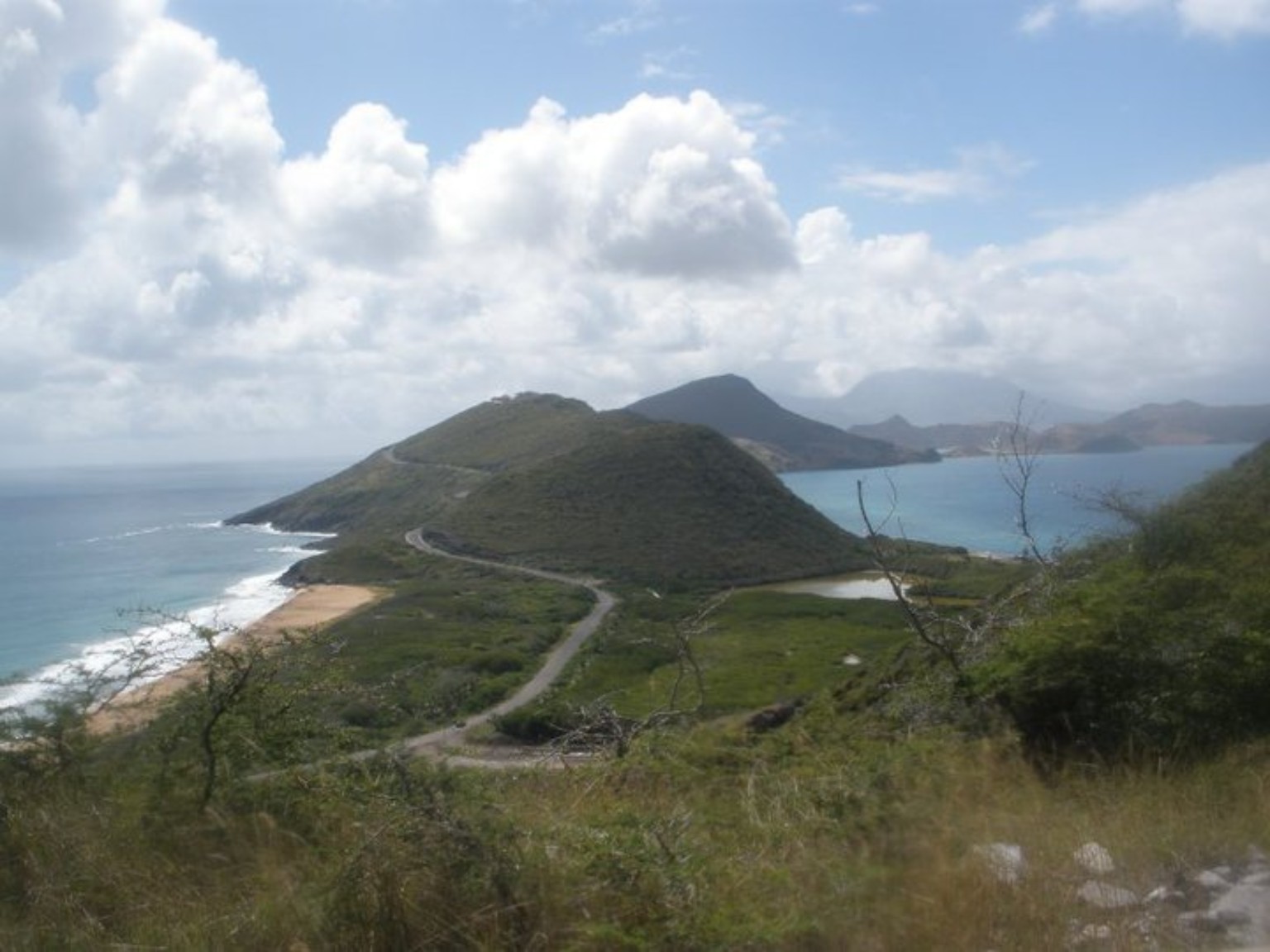 Rolling green hills and beaches in St. Kitts with Nevis in the distance