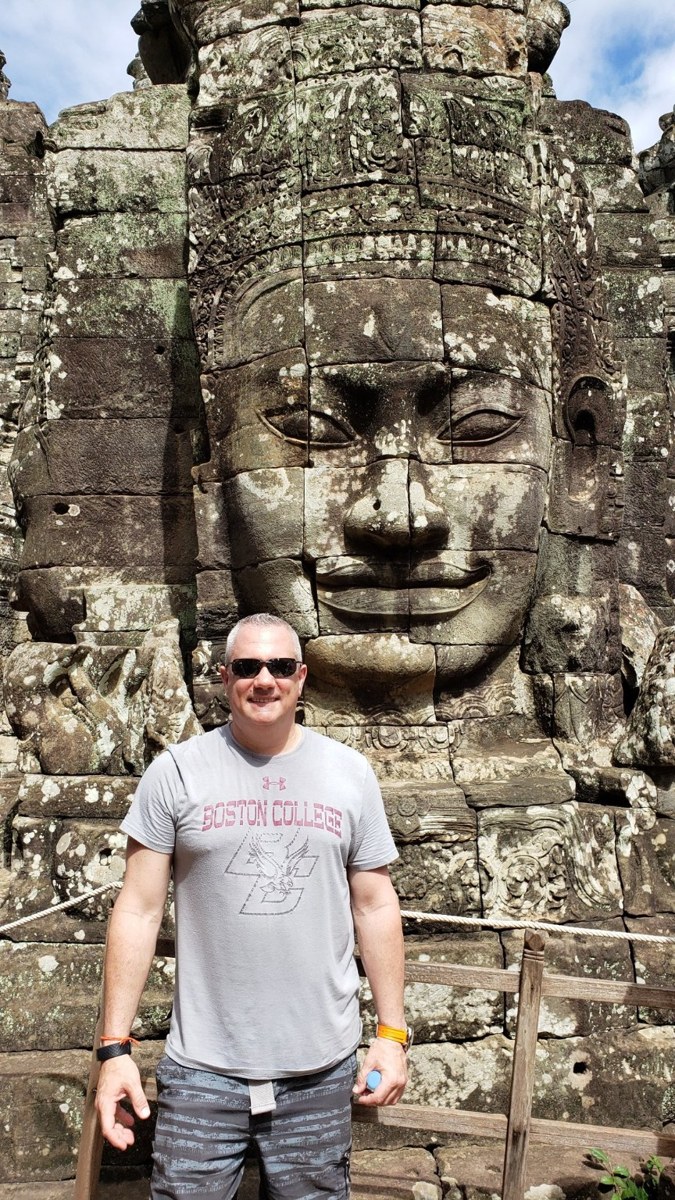 Standing in front of one of Bayon's iconic carved stone faces