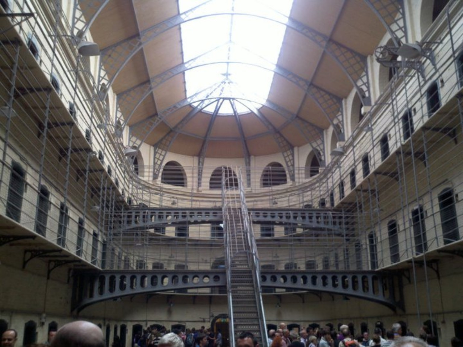 Interior skylit hall of Kilmainham Gaol with iron railings and cell doors