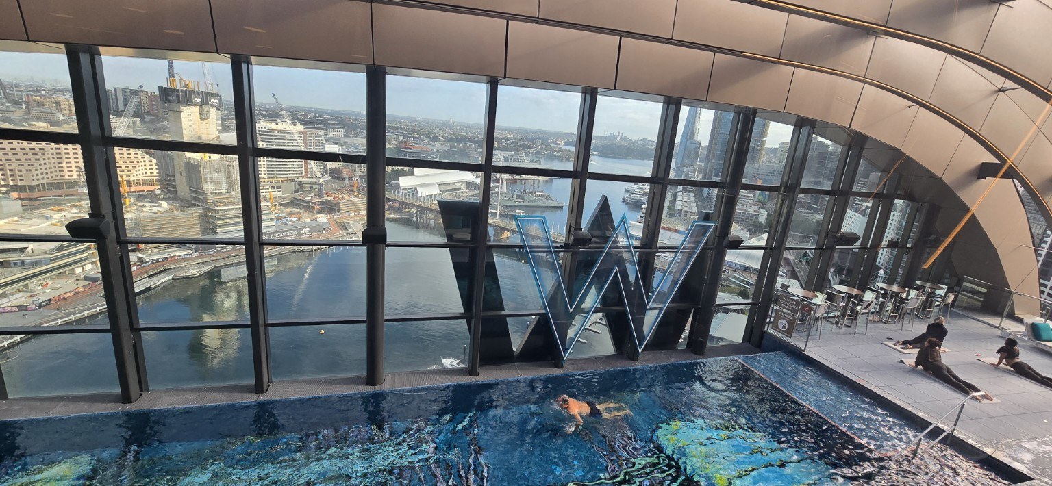 Indoor pool at the W Sydney with a curved, wave-like glass roof