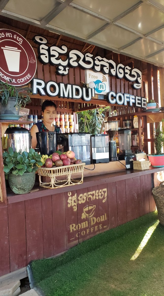 A cup of Cambodian coffee on a wooden table at a Siem Reap café