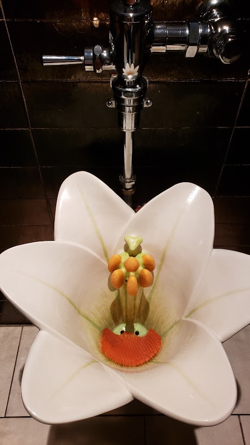 A flower-shaped urinal in a men's restroom at Harry's in Bermuda