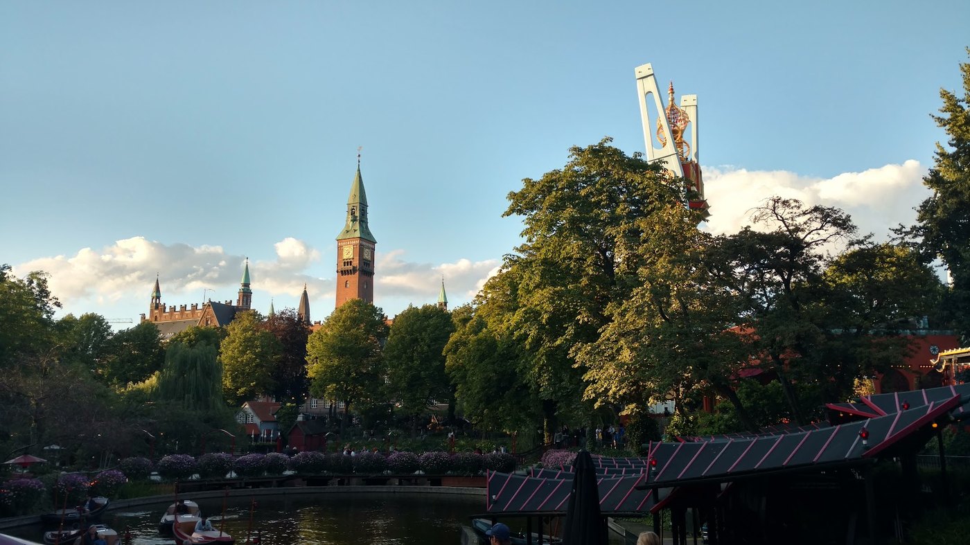 Tivoli at golden hour, with City Hall rising beyond the trees
