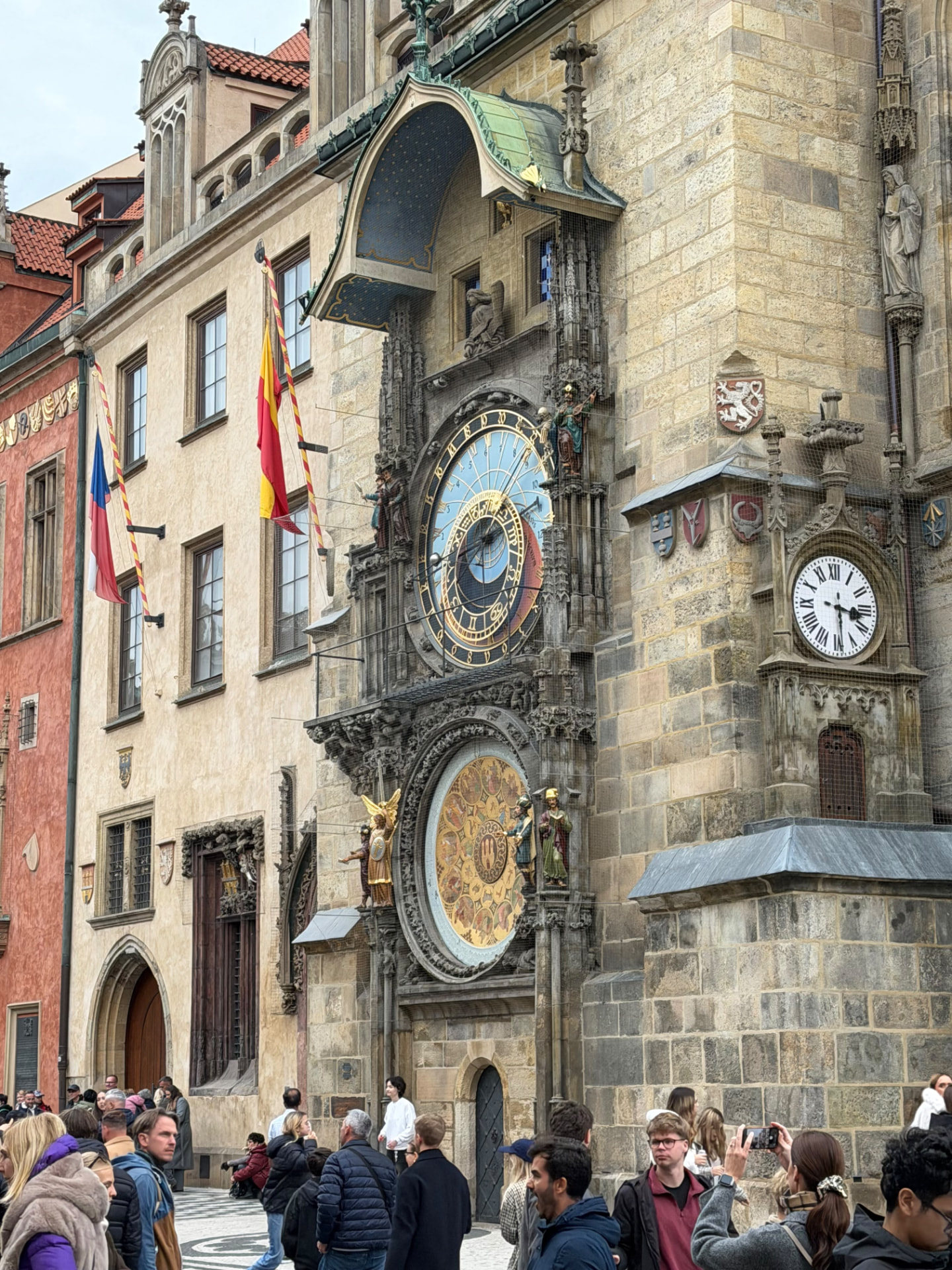 The Prague astronomical clock on the Old Town Hall in Old Town Square, with flags and the calendar dial below