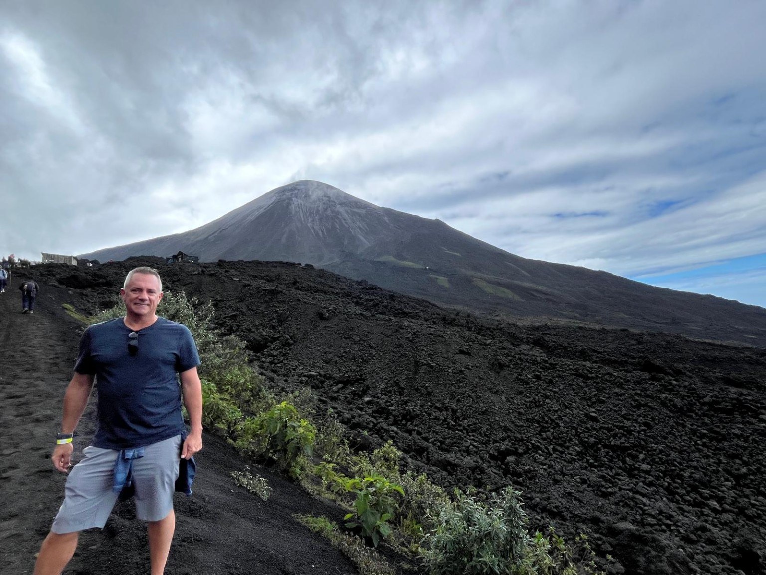 Scott standing on a black lava field below Pacaya volcano in Guatemala