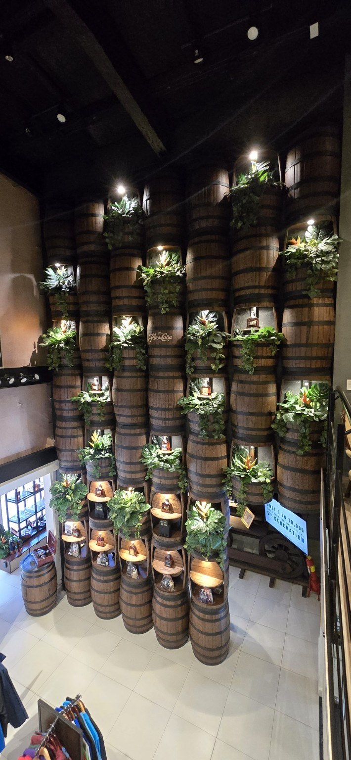 A wall of Flor de Caña rum barrels stacked high inside the Nicaraguan distillery tasting room