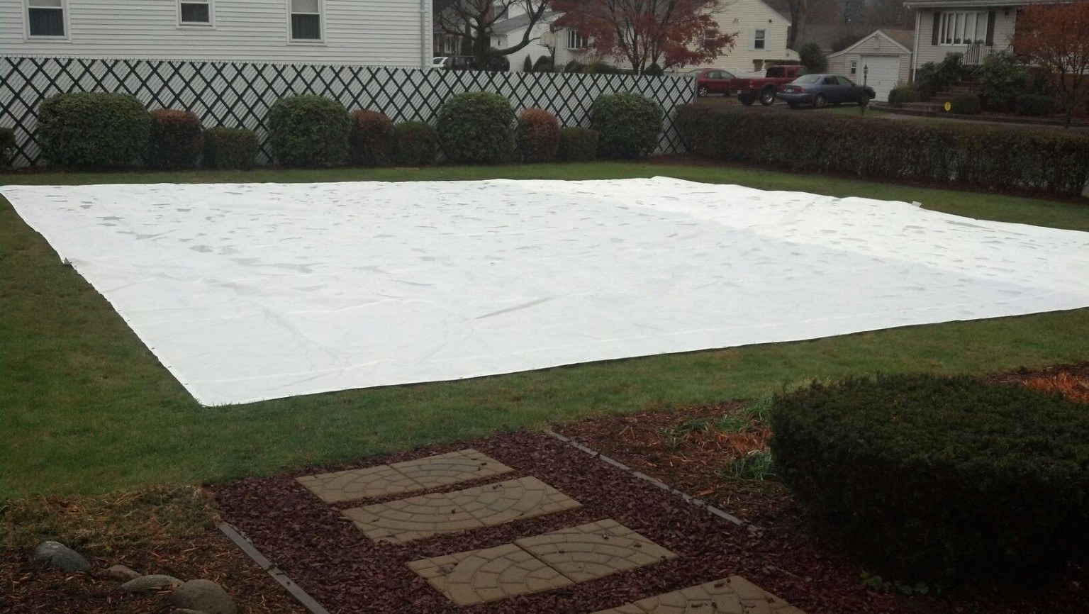 Large white tarp spread over a snowy lawn