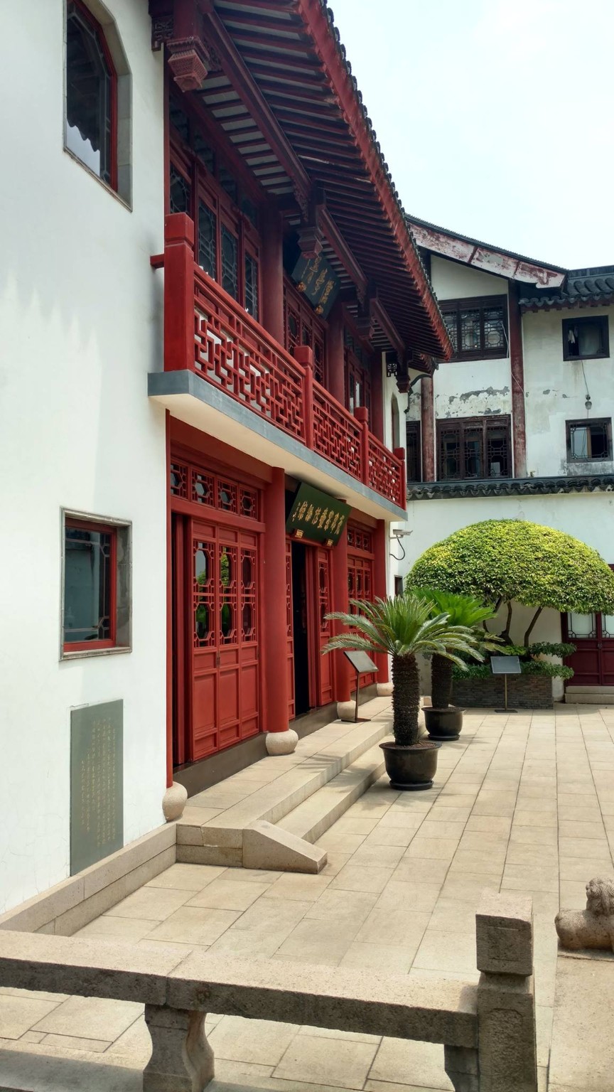 A quiet traditional courtyard framed by red woodwork and white walls
