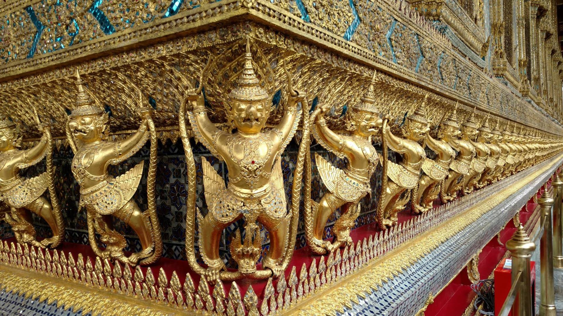 Row of golden Garuda figures lining the base of the Royal Pantheon