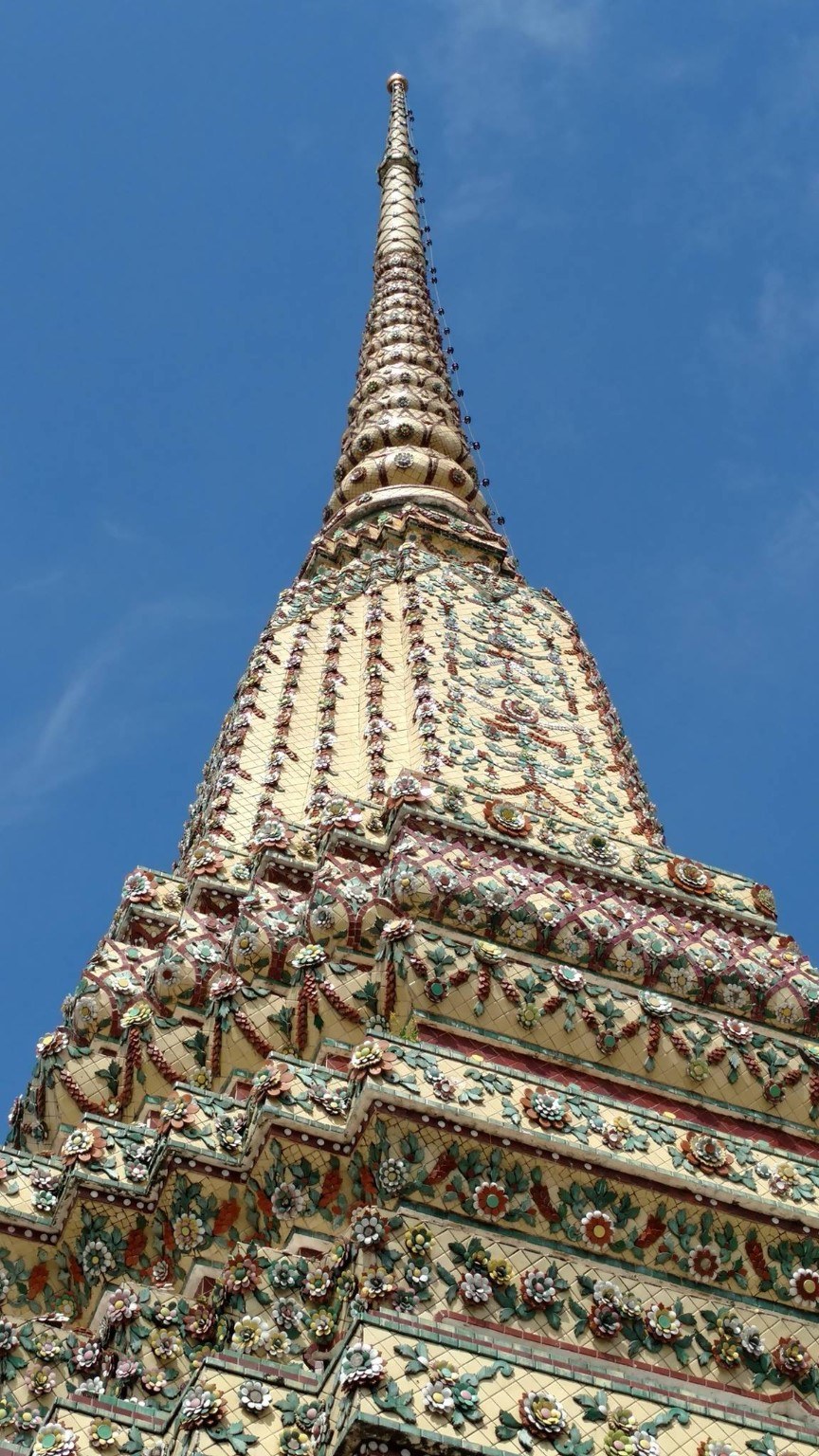 Floral ceramic tilework climbing a temple chedi at Wat Pho