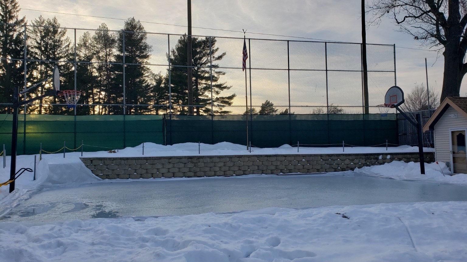 Basketball court converted into a backyard ice rink in winter