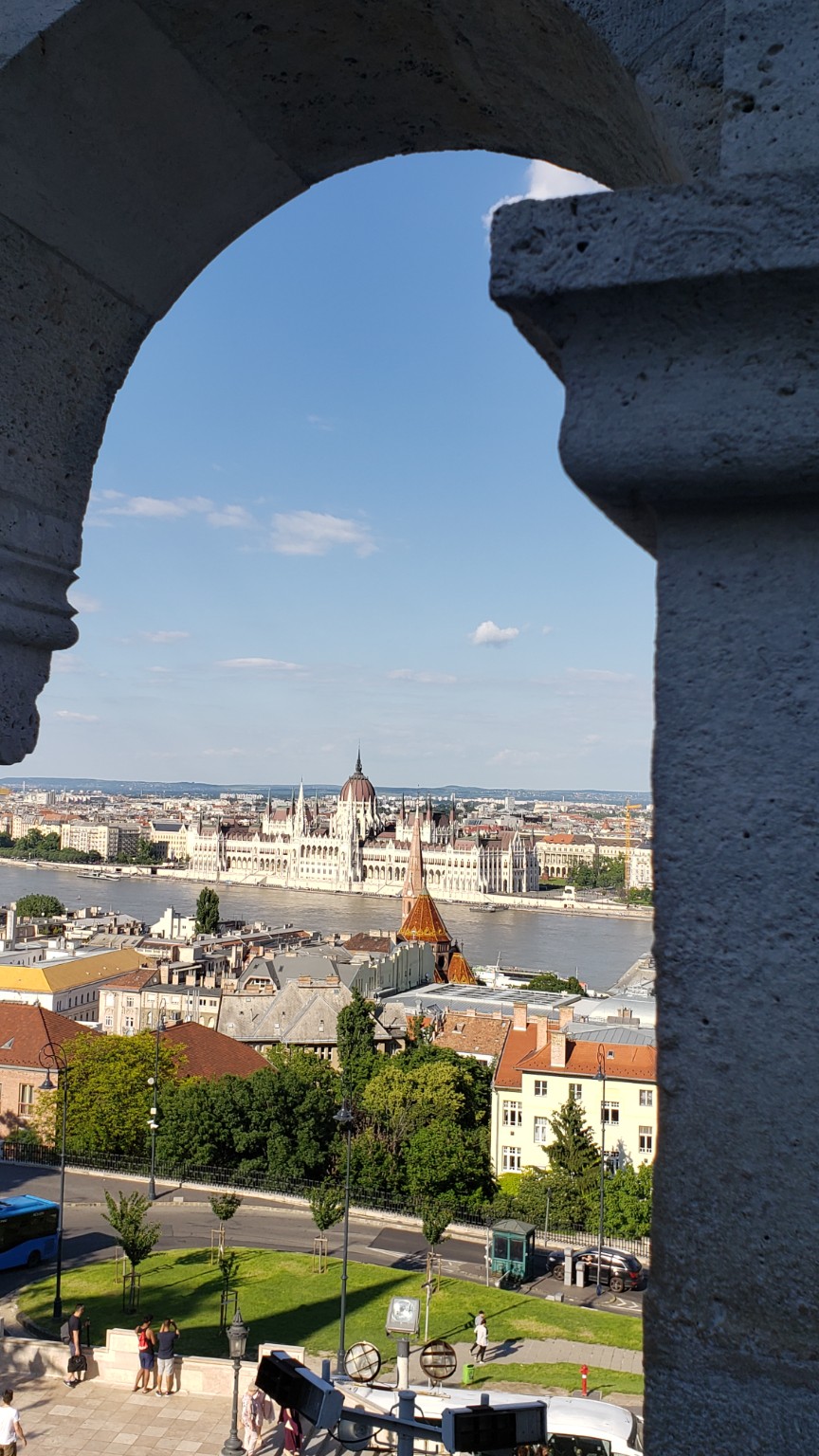 The Hungarian Parliament Building framed through the stone arches of Fisherman's Bastion