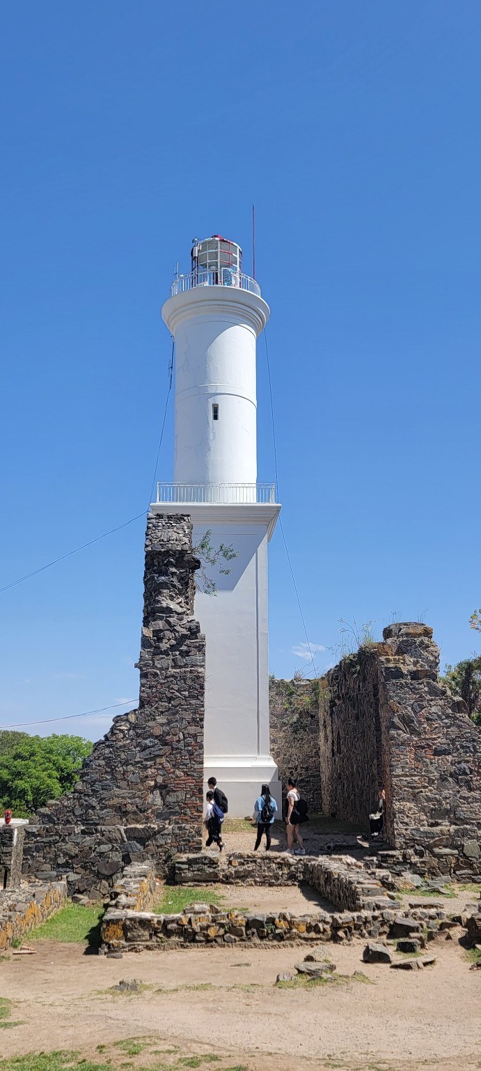 White lighthouse rising from stone ruins in Colonia del Sacramento, Uruguay