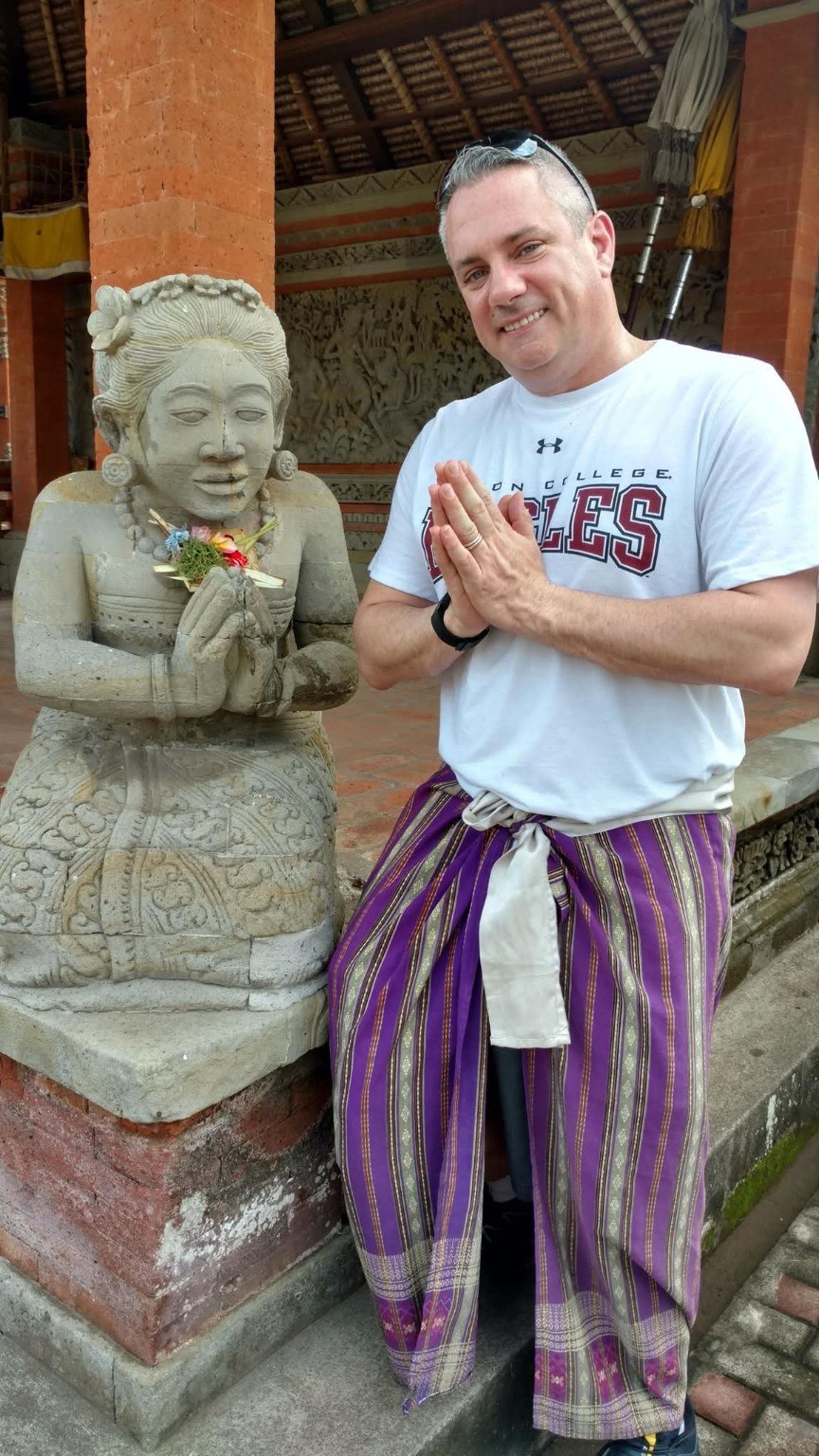 A temple moment with a carved figure and fresh offerings