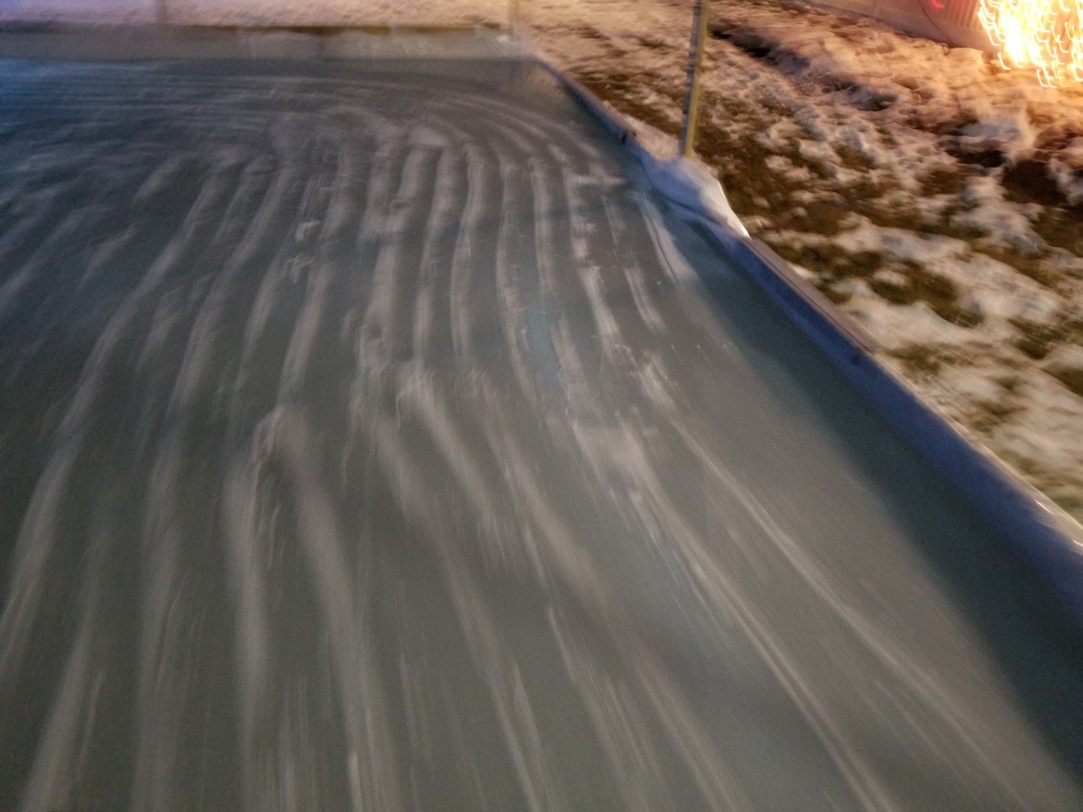 Streaks of freshly laid water from a homemade Zamboni on backyard ice