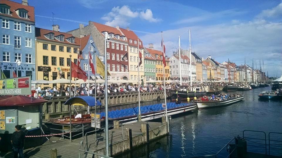 Nyhavn waterfront in Copenhagen, painted townhouses and wooden boats along the canal