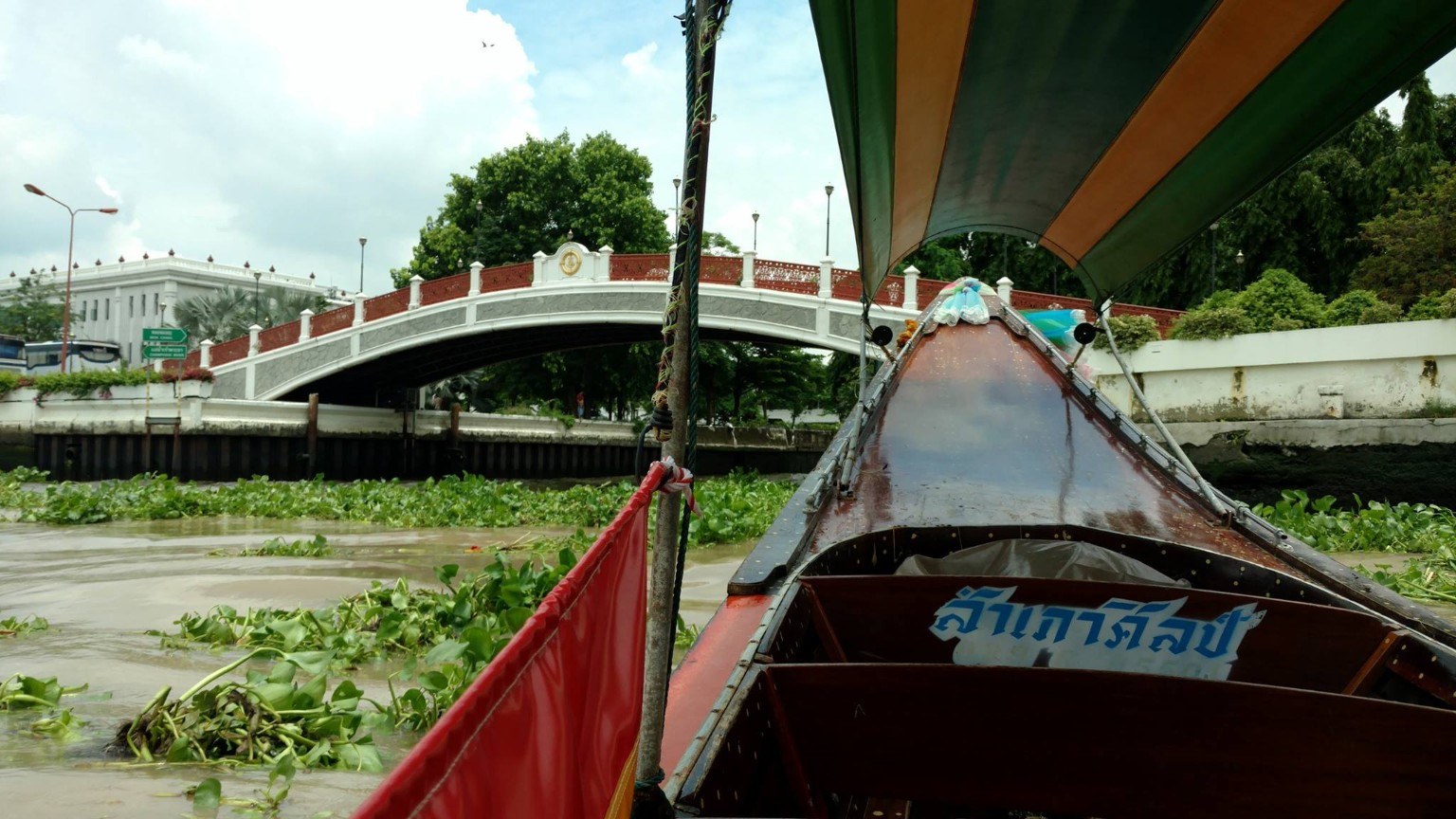 A long-tail boat moving through Bangkok's canals