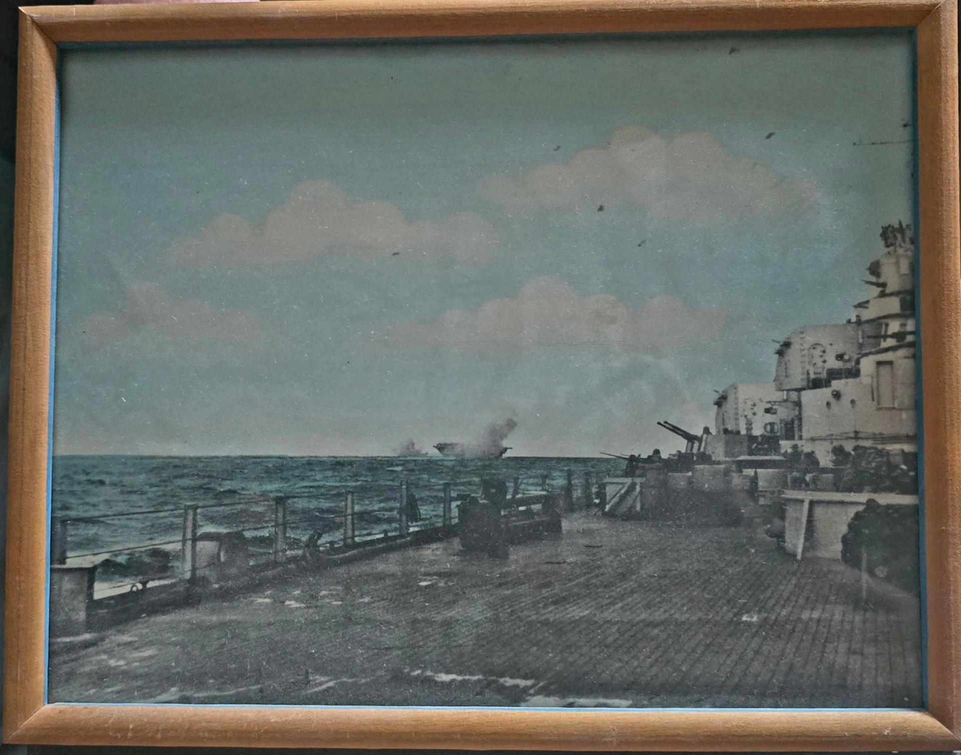 Photograph from the deck of a U.S. Navy warship at sea, with smoke on the horizon