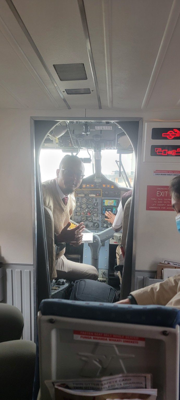 Inside the cabin of a small AirKenya bush plane with passengers and pilots in view