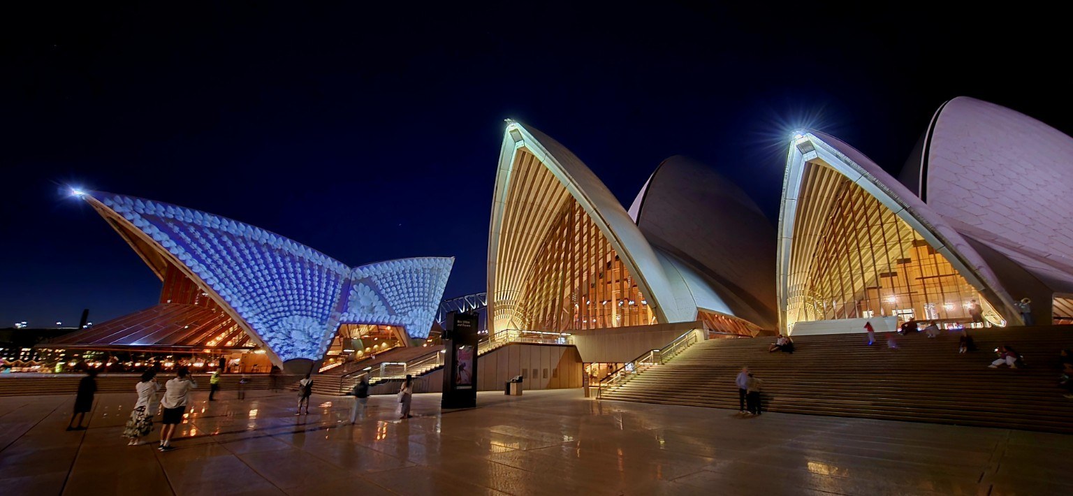 Opera House sails lit with projections at dusk