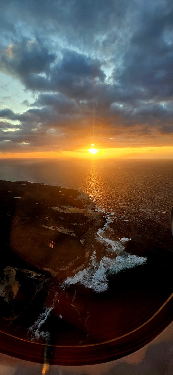 Sunset over the Australian coastline seen from a plane window